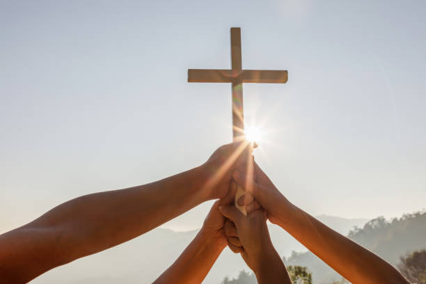 istock Christian, Christianity, Religion copy space background. Group hands praying and holding christian cross for worshipping God at sunset background.silhouette 1475690091