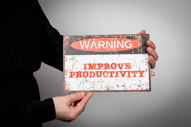 istock Improve Productivity Concept. Warning sign with text on a white background in a woman's hand 1475695446