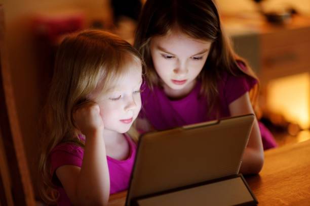 istock Two adorable little sisters playing with a digital tablet 1475701195