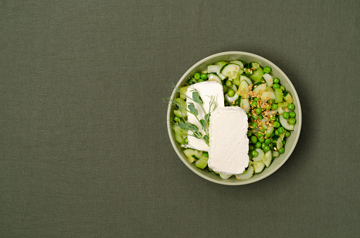 Salad green vegetables, white flax seeds and cheese slices on a textile background. Top view.