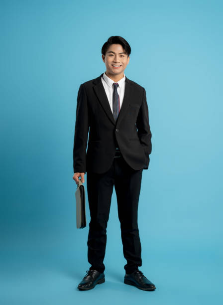 istock image of young businessman posing on a blue background 1475707867