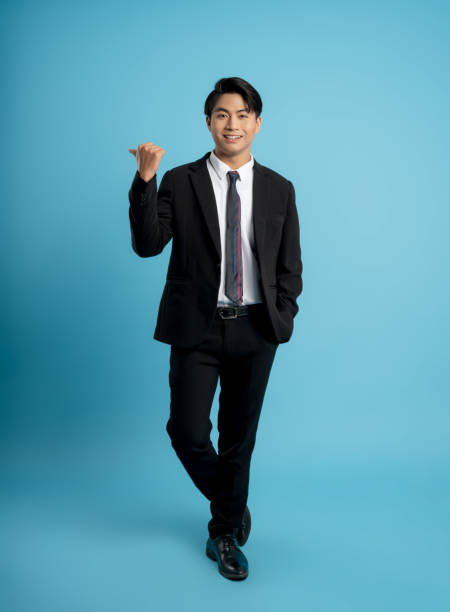istock image of young businessman posing on a blue background 1475707873