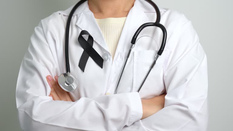 Melanoma and skin cancer, Vaccine injury awareness month and rest in peace concepts. doctor holding black Ribbon