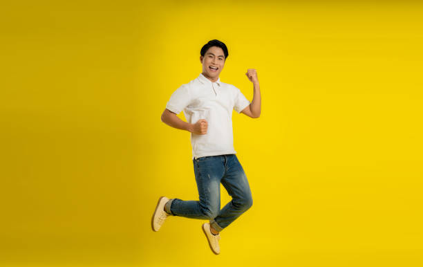 istock Full length image of young Asian man on yellow background 1475708202