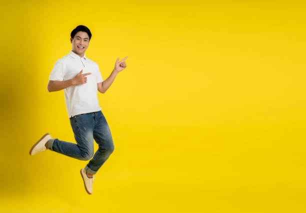 istock Full length image of young Asian man on yellow background 1475708204