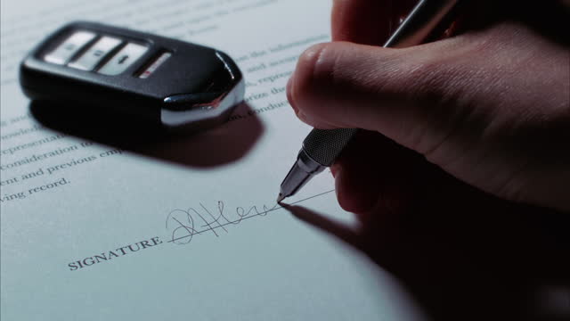 Caucasian Hand Signs Signature on Contract/Application with Car Key