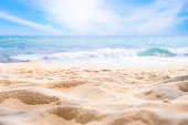 Beach sand background for summer vacation concept. Beach nature and summer seawater with sunlight light sandy beach Sparkling sea water contrast with the blue sky.