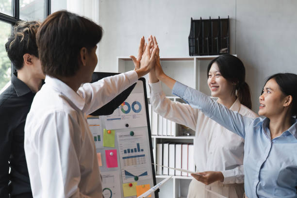 istock Group of business diversity workers standing with hands together high five at the office 1475729592