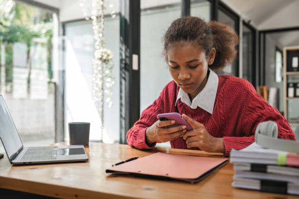 istock Young woman holding mobile phone at cafe. Student typing message using messenger or customer buying goods online concept 1475731813