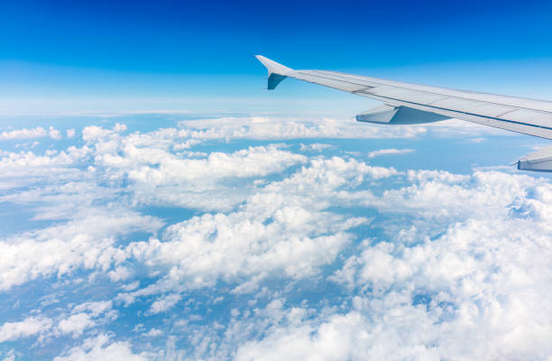 istock View from the airplane window at a beautiful cloudy sky and the airplane wing 1475732507