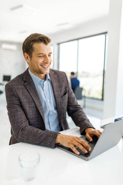 istock Happy businessman working on laptop at corporate office. 1475740773