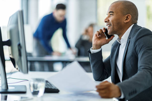 istock Happy black businessman talking on cell phone in the office. 1475741493