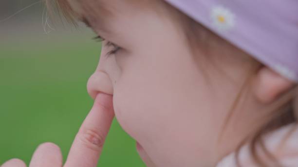 istock Young Caucasian Girl Picking Nose with Index Finger Front 1475757177