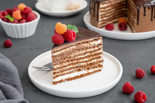 Layered honey chocolate cake with glaze and fresh raspberries on top. Delicious chocolate cake
