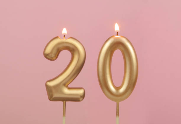 Golden birthday candles on pink background, number 20 stock photo