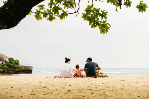 familia asiática con su bebé sentado en la arena y disfrutar de la puesta de sol - group of people journey effort travel destinations fotografías e imágenes de stock