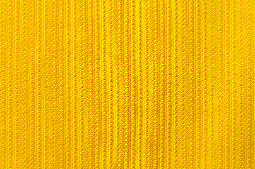 Yellow color sports clothing fabric football shirt jersey texture and textile background.