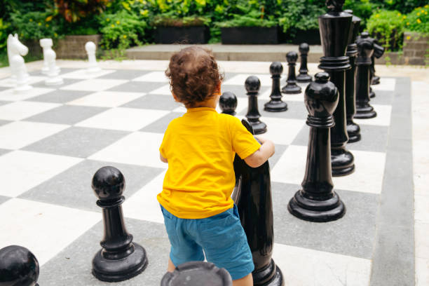 istock Baby playing a giant chess on a public park 1475759762