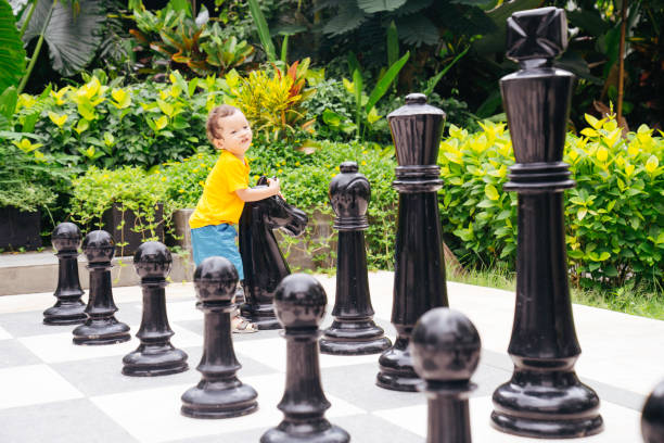 istock Baby playing a giant chess on a public park 1475759869