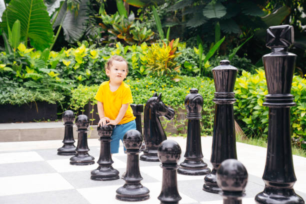 istock Baby playing a giant chess on a public park 1475759968