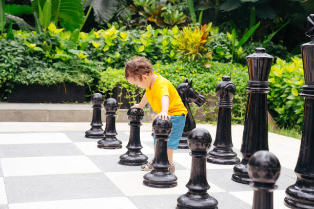 istock Baby playing a giant chess on a public park 1475760000