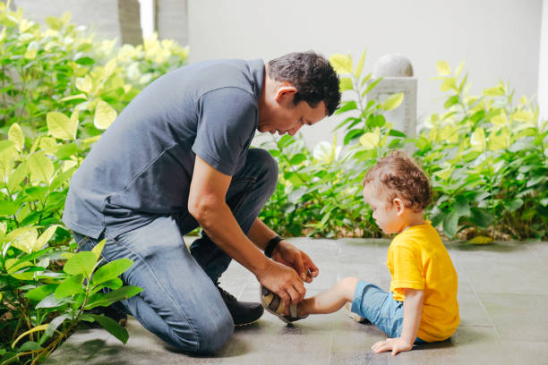istock Father helping his son put his shoes on 1475761196