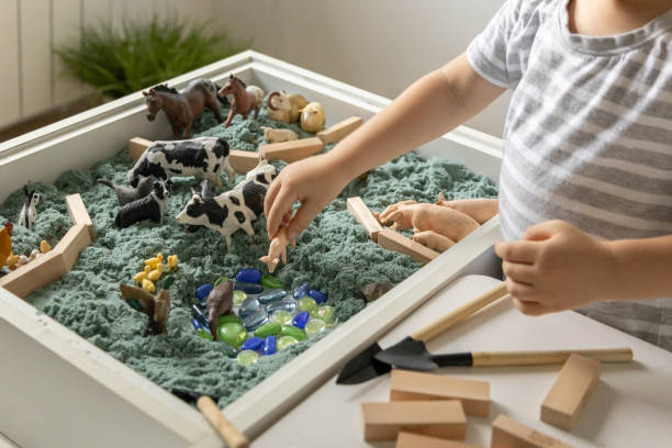 istock Cute baby boy playing sensory box kinetic sand table with farm animals 1475762985