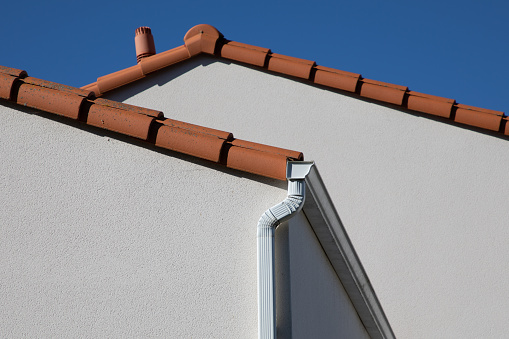 Corner of modern new facade house with gutter and ventilation chimney