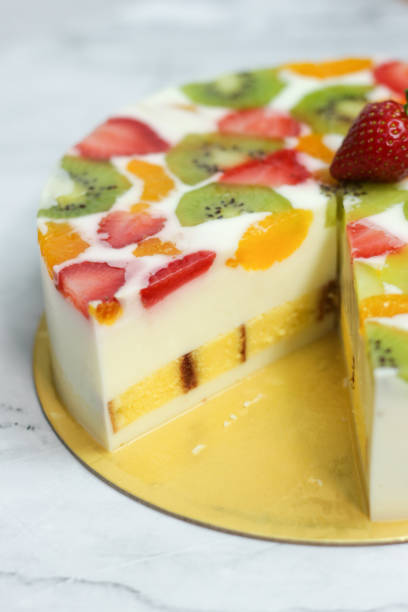 istock Pieces of Homemade Fruit Pudding served on white plate, fork on table. soft white pudding with ingredients of strawberries, oranges, kiwi. Selective focus. 1475766831