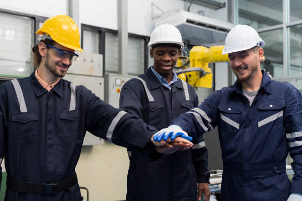 istock Group of diversity male engineer workers standing and putting hands together at production line in the industry factory 1475769748