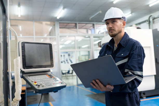 istock Male engineer worker working with laptop computer for control machine in the workshop. Male worker working with lathe machine with safety uniform and helmet in the industry factory 1475769753