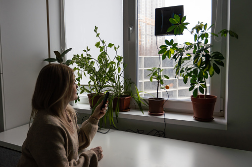 Woman cleaning windows at home with robotic cleaner