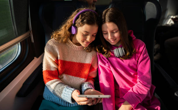 istock Girls playing with digital tablet in train 1475775290