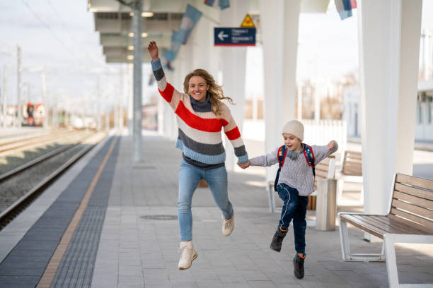 Mother and son at the station running, catching the train Happy mother and son at the station running, catching the train running to catch the train stock pictures, royalty-free photos & images