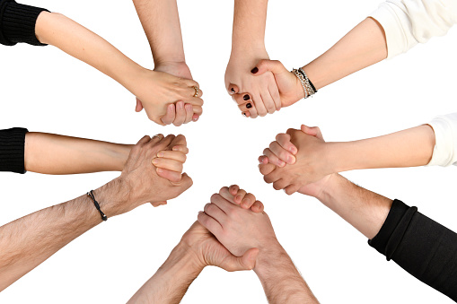 Group of unidentifiable people holding hands in a circle
