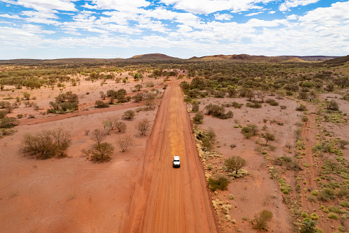 4x4 car driving down a dusty red earth road in outback Australia