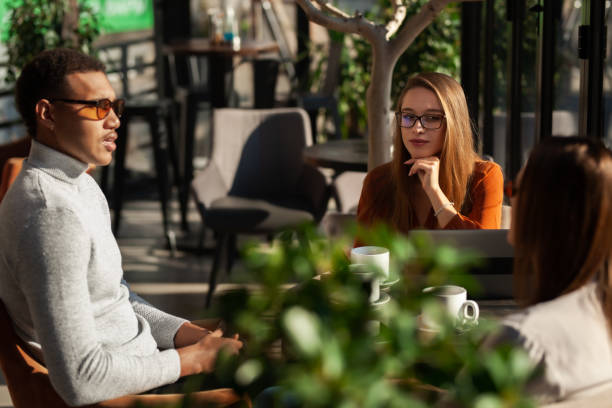 istock Three friends in a restaurant talking smiling and drinking tea. Business colleagues having a meeting after work or during coffee break at a cafe bar.. 1475782713