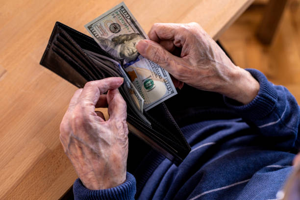 istock Close-up of elderly human hands counting money 1475784382