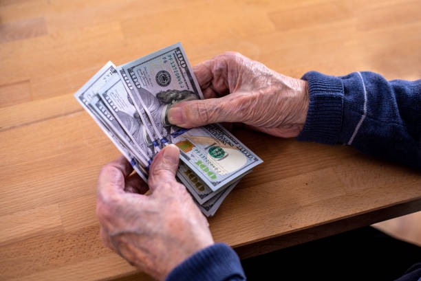 istock Close-up of elderly human hands counting money 1475784401