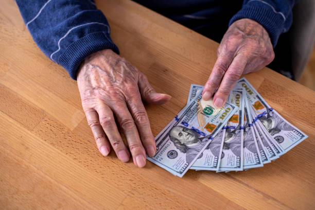 istock Close-up of elderly human hands counting money 1475784404