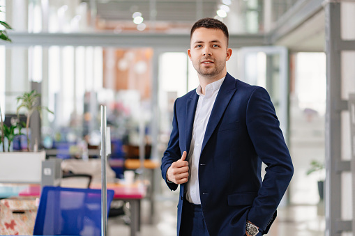a man in ablue business suit in the coworking office. the concept of the portrait of an entrepreneur. career. simple and comfortable clothes for an office worker. office for rent