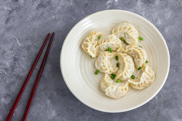 Chicken Dumplings in a Plate with Chopsticks Directly Above Photo stock photo