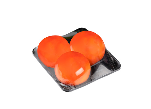 Organic Tomatoes in black package tray with plastic wrapping isolated on white background with clipping path.