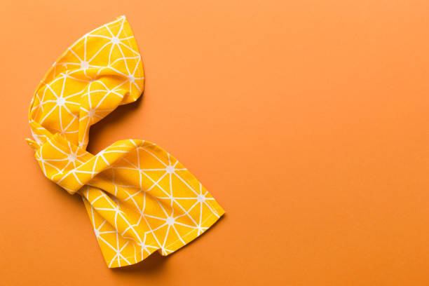 top view with yellow empty kitchen napkin isolated on table background. Folded cloth for mockup with copy space, Flat lay. Minimal style.
