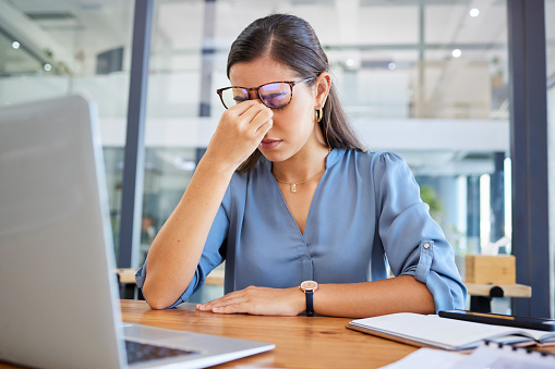 Stress headache, burnout and woman in office overwhelmed with workload at desk with laptop. Frustrated, overworked and tired woman with computer at startup, anxiety from deadline time pressure crisis