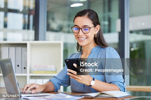 istock Business woman, laptop and smile for phone, communication or reading at the office. Happy female employee event planner checking email, social media or post on smartphone and computer at workplace 1475798875