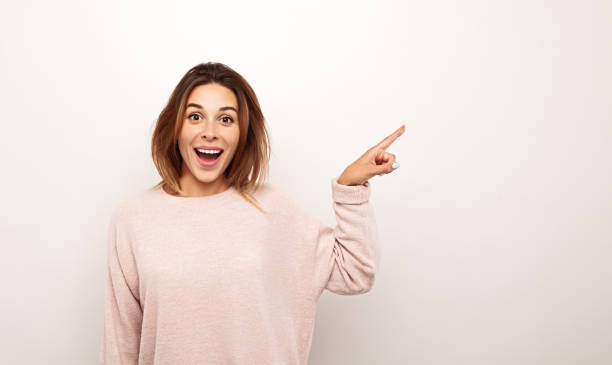 istock Amazed young woman pointing away 1475800743