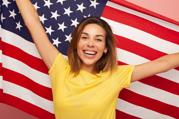 istock Excited young lady with American flag smiling at camera 1475800776