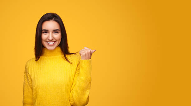 istock Positive female pointing away with thumb 1475804322