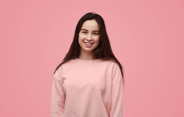 istock Optimistic young female millennial smiling at camera in pink studio 1475805843